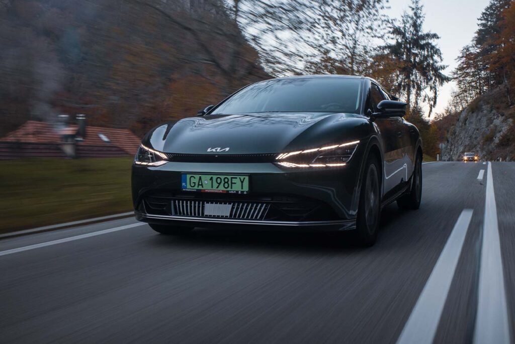 Czarnia KIA EV6 jadąca po asfaltowej drodze w górach